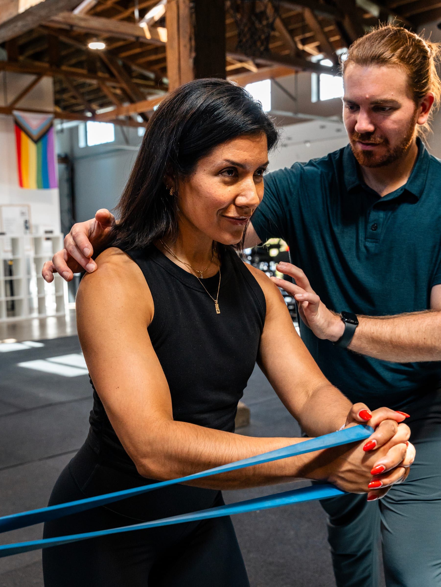 Adam Wilson guiding a client through a banded shoulder exercise