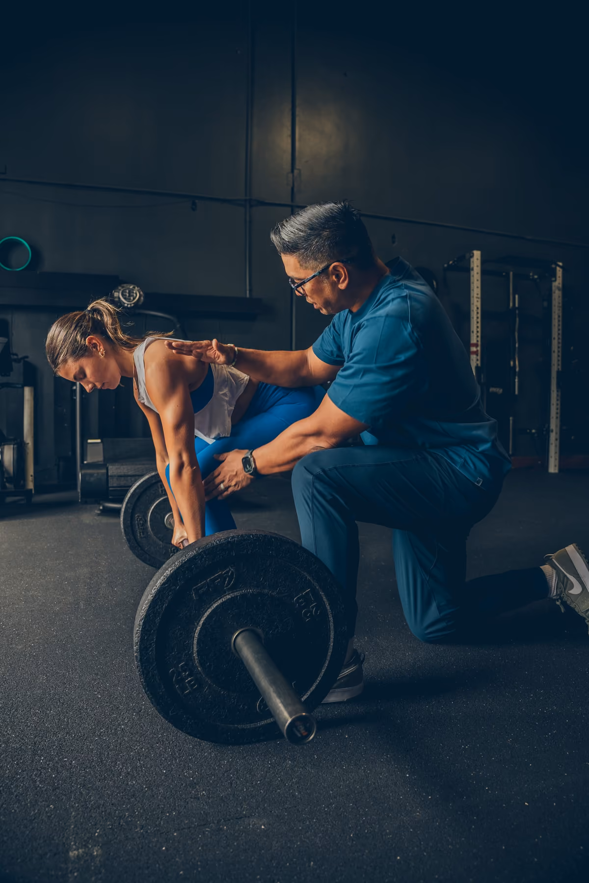 Jay Villareal coaching a client through a barbell deadlift